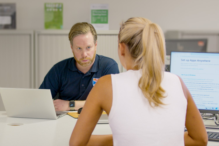 A student receiving IT help in the Main Library